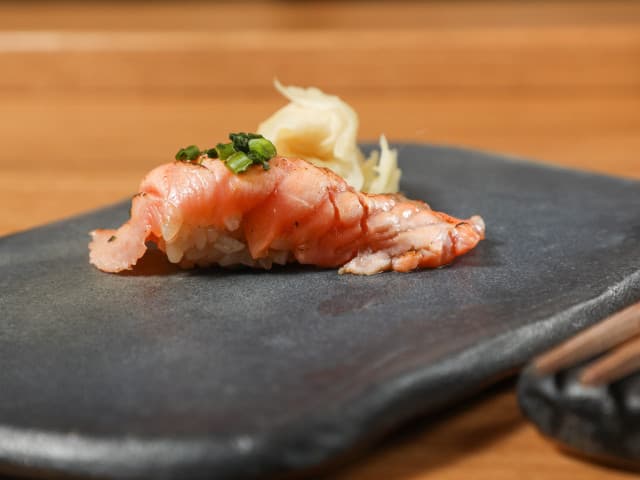 Nigiri sushi with salmon and scallop on dark slate plate