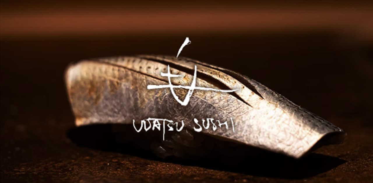 Close-up of sushi fish on dark surface with logo overlay