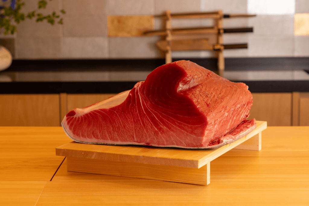 Raw tuna fillet displayed on wooden board in minimalist dining room