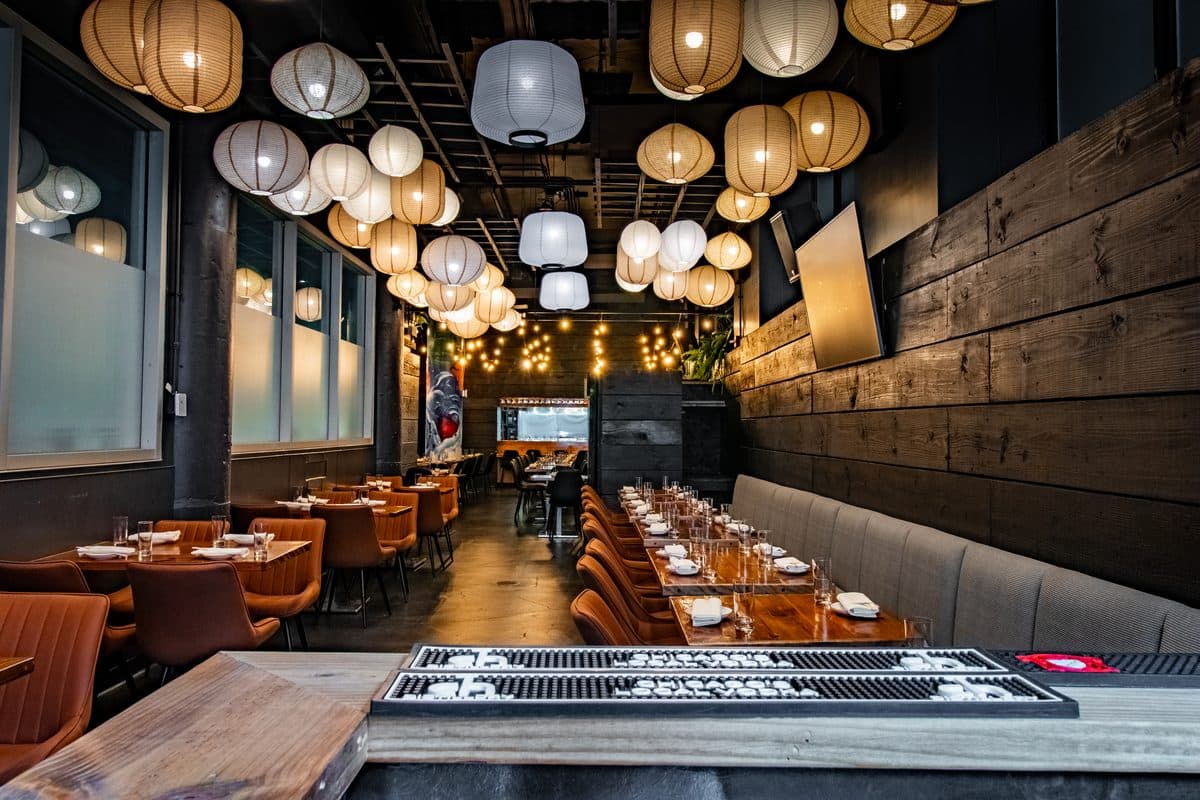 Modern restaurant interior with paper lantern lighting, wooden accents, and dining tables