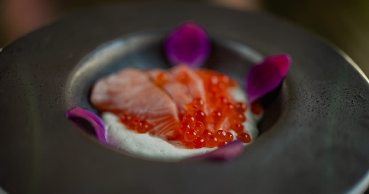 Plate of sashimi with salmon roe and purple flower petals