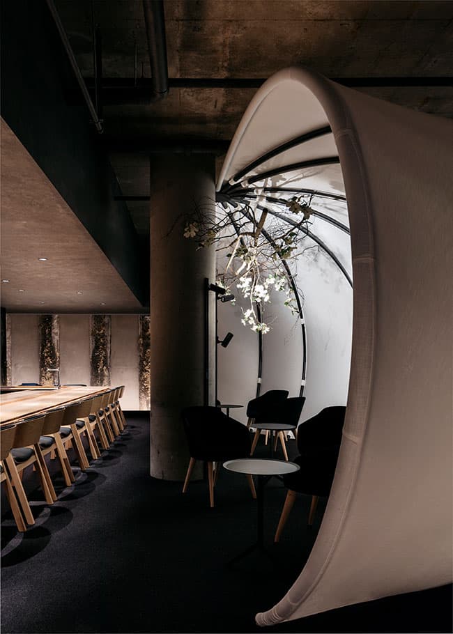 Modern dining area with sculptural white partitions and wooden chairs