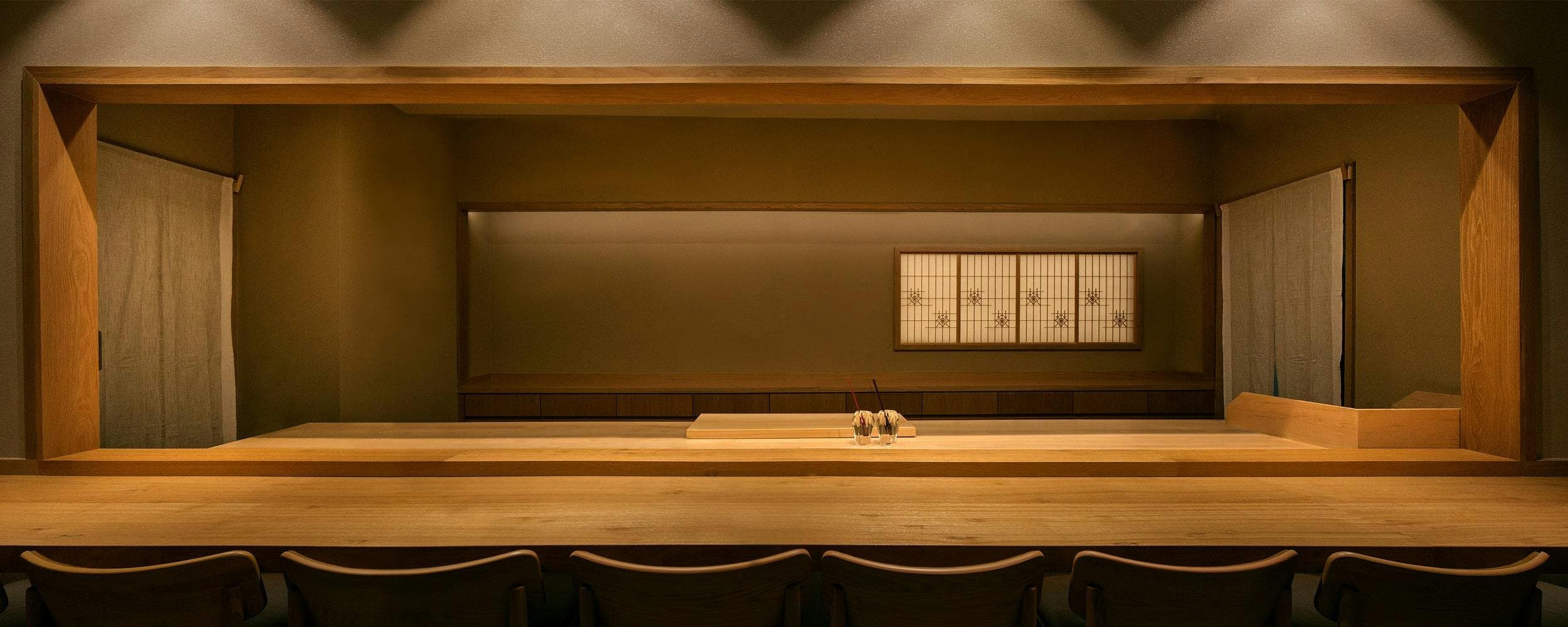 Minimalist sushi preparation counter with wooden surfaces and Japanese-style decor
