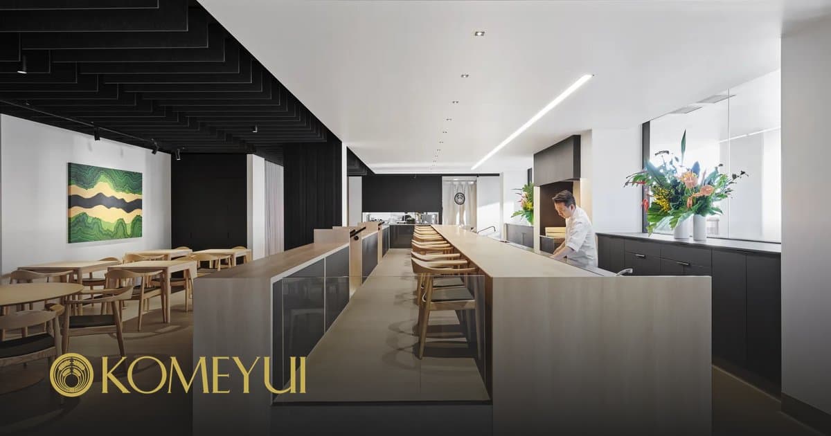 Modern Japanese restaurant dining counter with black and white design, wooden seating, and professional lighting