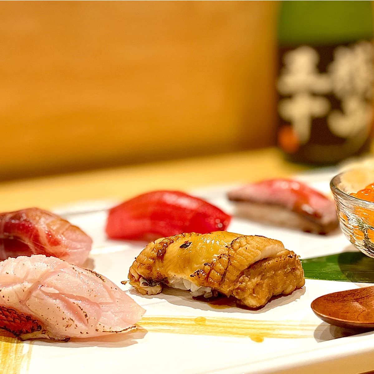 Plated sushi selection with nigiri and garnishes on white plate