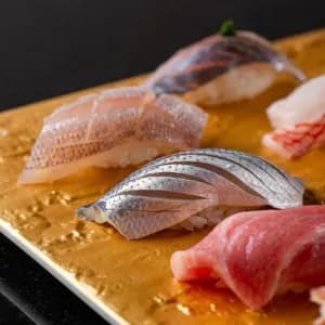 Assorted raw fish and seafood arranged on a wooden board with garnish