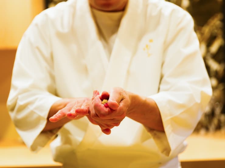 Therapist in white coat holding flower petals in hands